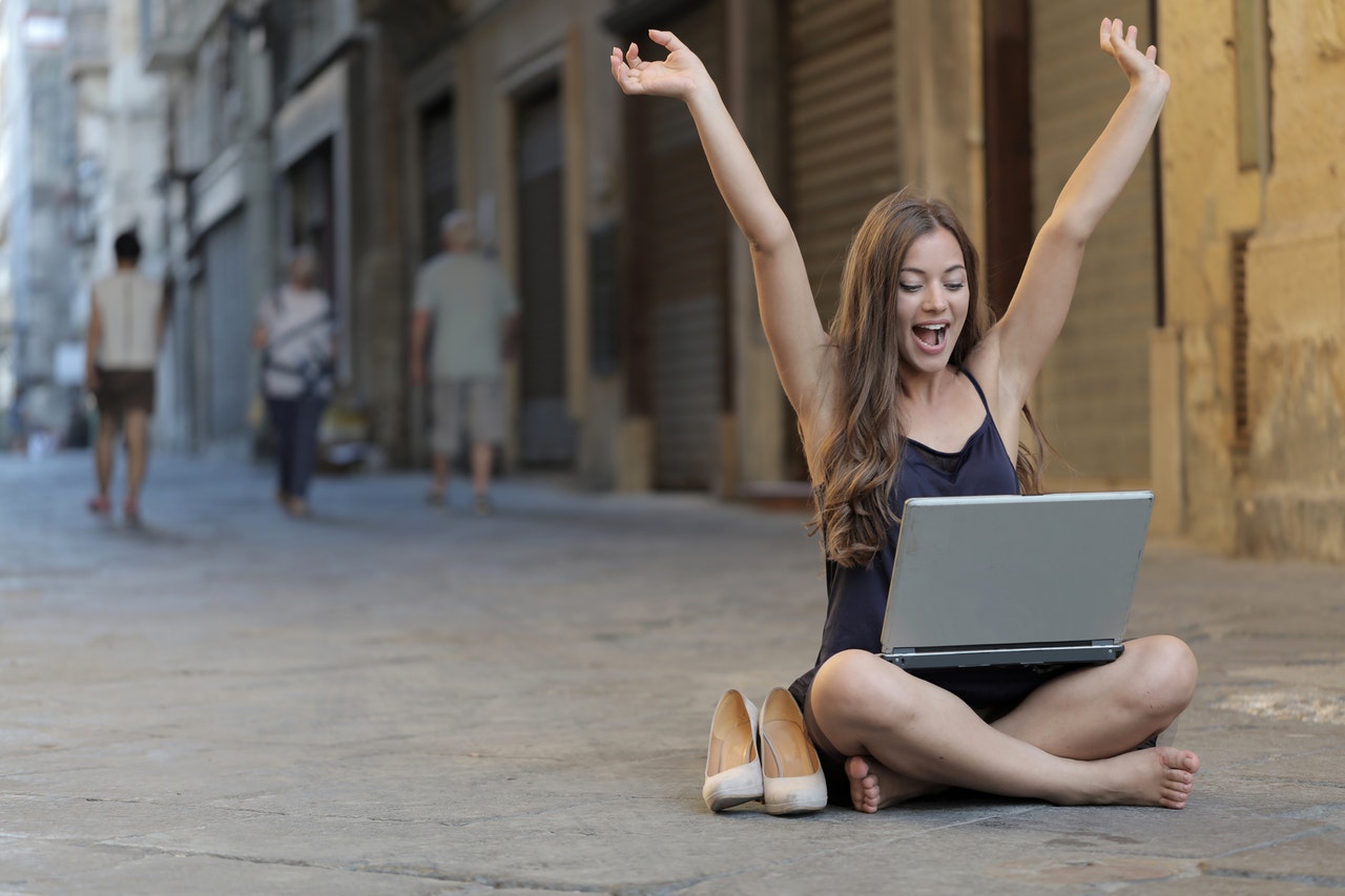 super monologue woman sitting on street raise hands with computer
